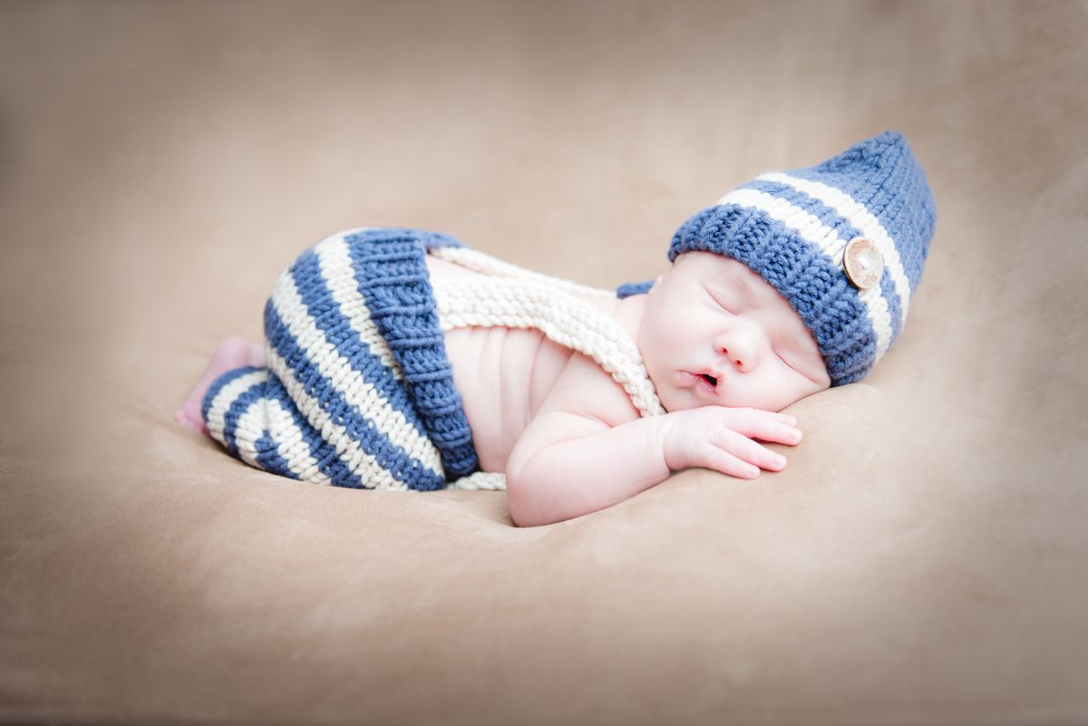 Newborn baby boy in blue knit outfit